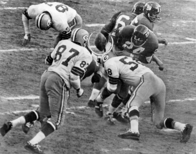 The ball squirts from the arms of New York Giant halfback Phil King (24) as he’s hit by Dan Currie (58) of the Green Bay Packers during the second quarter of NFL championship game at New York's Yankee Stadium on Dec. 30, 1962. Packers won 16 to 7.