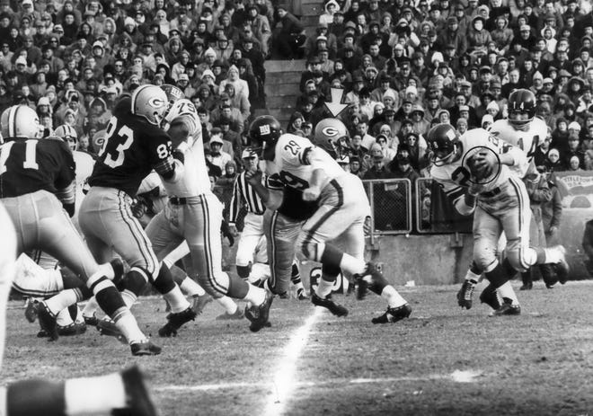 The New York Giants quarterback Y.A. Tittle (14) handed off to halfback Joel Wells during the NFL Championship game on Dec. 31, 1961, against the Packers at New City Stadium in Green Bay. The Packers won 37-0.