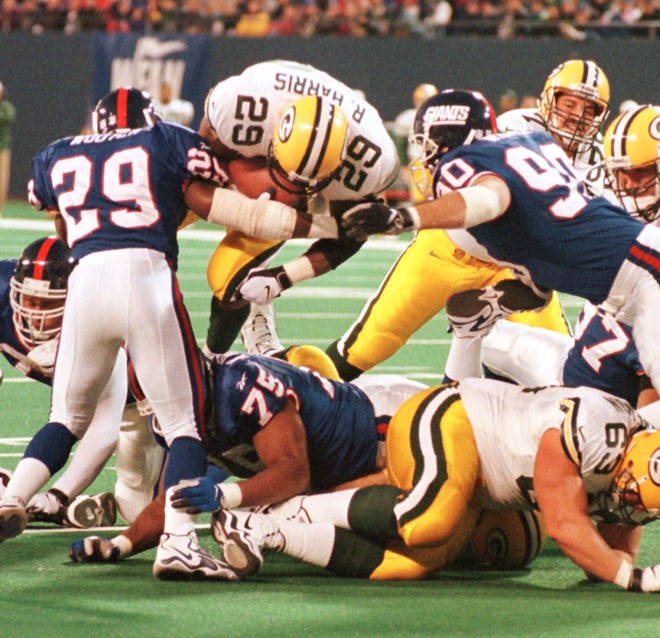 Green Bay Packers running back Raymont Harris (29) comes over the top for a 4-yard gain before being stopped at the two-yard line by New York Giants Tito Wooten (29) and Corey Widmer (90) during the first quarter on Nov. 15, 1998 at Giants Stadium in East Rutherford, N.J.
