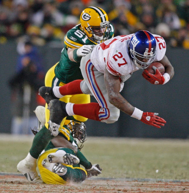 New York's Brandon Jacobs runs over Packer defenders during the second first half of their game at Lambeau Field in Green Bay, Sunday, Jan 20, 2008.