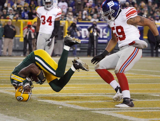 Green Bay Packers Donald Driver holds onto the ball in the end zone for a 16-yard touchdown pass reception against the New York Giants in the 4th quarter of their NFC divisional playoff game on January 15, 2012 at Lambeau Field in Green Bay, Wisconsin. The Giants won, 37-20.