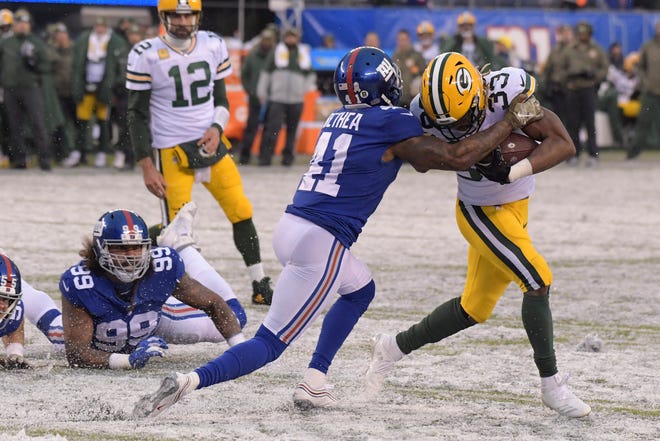 New York Giants' Antoine Bethea, left, tries to bring down Green Bay Packers' Aaron Jones during the second half of an NFL football game, Sunday, Dec. 1, 2019, in East Rutherford, N.J.