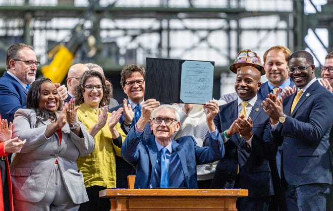 Gov. Tony Evers signs Assembly Bill 438 and Assembly Bill 439, a bipartisan package of bills passed by the Wisconsin State Legislature to keep the Milwaukee Brewers and Major League Baseball (MLB) in Wisconsin through 2050, on Tuesday December 5, 2023 at American Family Field in Milwaukee, Wis.