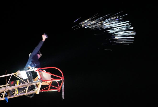 A Northshore firefighter tosses gelt, or chocolate coins from a ladder truck as part of a Chanukah Festival and Gelt Drop, to kick off the first day of Chanukah, in The Yard at Bayshore in Glendale on Thursday, Dec. 7, 2023. The largest Hanukkah festival in Wisconsin, hosted by Lubavitch of Wisconsin, included live music, a giant Menorah lighting, and a mega gelt and gift drop.