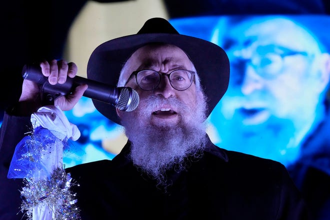 Rabbi Mendel Shmotkin speaks as part of a Chanukah Festival and Gelt Drop, to kick off the first day of Chanukah, in The Yard at Bayshore in Glendale on Thursday, Dec. 7, 2023. The largest Hanukkah festival in Wisconsin, hosted by Lubavitch of Wisconsin, included live music, a giant Menorah lighting, and a mega gelt and gift drop.