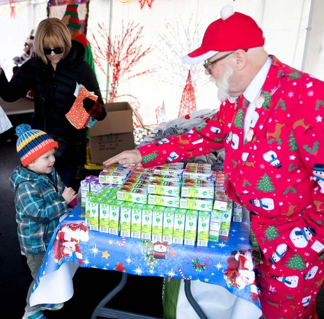 Greg Peterson hands Quinn H., 3, a juice box after he met Santa during the Cocoa with the Clauses event in Cathedral Square Park in Milwaukee, Wis. on Saturday, Dec. 9, 2023.
