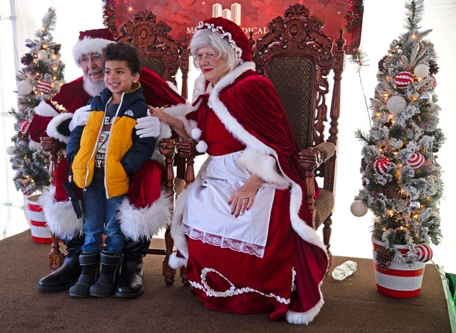 Solomon Spiekermann, 5, takes a photo with Santa and Mrs. Clause during the Cocoa with the Clauses event in Cathedral Square Park in Milwaukee, Wis. on Saturday, Dec. 9, 2023.