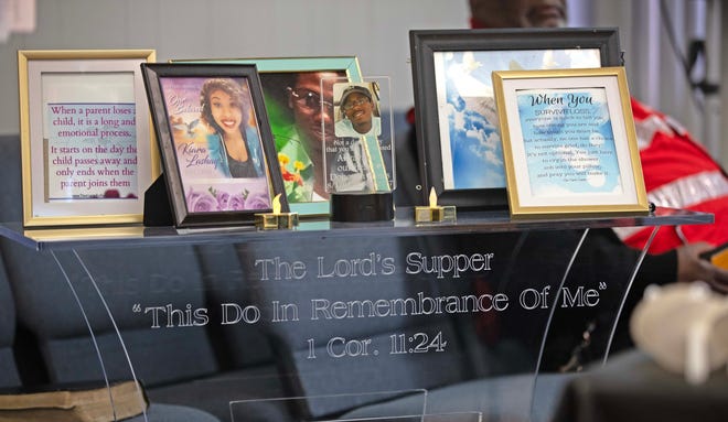Photos of those lost to violence and encouraging words are displayed at the front of the church during a candlelit vigil honoring and remembering victims of violence in Milwaukee at House of Prayer in Milwaukee, Wis. on Saturday, Dec. 9, 2023.