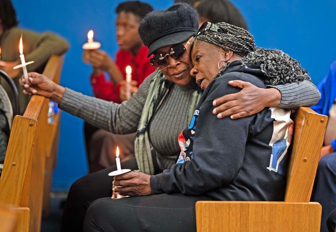 A friend comforts Julie Powell during a candlelit vigil honoring and remembering victims of violence in Milwaukee at House of Prayer in Milwaukee, Wis. on Saturday, Dec. 9, 2023.