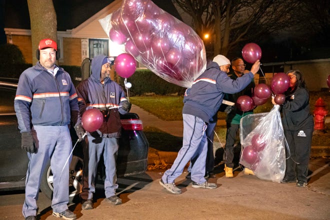 Community members pass out balloons to each other during a vigil on Dec. 9, 2023 honoring the life of Aundre Cross, a 44-year-old U.S. Postal Service worker who was shot and killed while delivering mail a year ago on Dec. 9, 2022 in the 5000 block of North 65th Street in Milwaukee.
