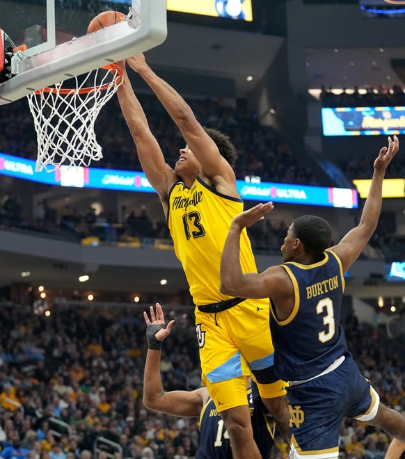 Marquette forward Oso Ighodaro (13) scores on Notre Dame guard Markus Burton (3) during the first half of their game Saturday, December 9, 2023 at Fiserv Forum in Milwaukee, Wisconsin.