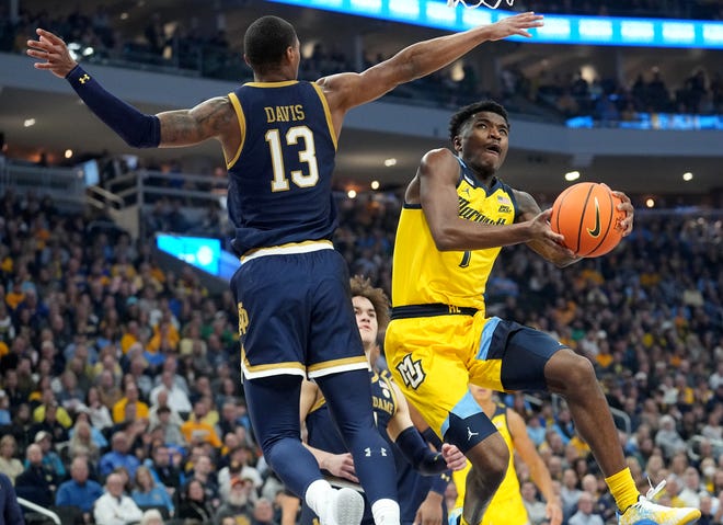Marquette guard Kam Jones (1) scores on Notre Dame forward Tae Davis (13) during the first half of their game Saturday, December 9, 2023 at Fiserv Forum in Milwaukee, Wisconsin.