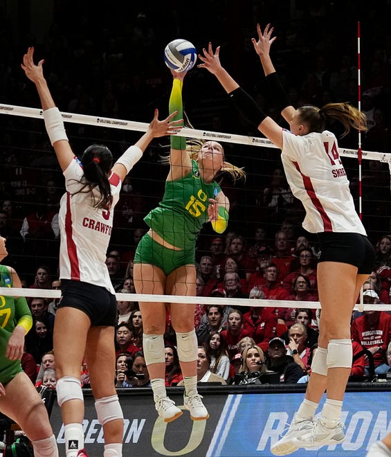 Wisconsin middle blocker Caroline Crawford (9) and opposite Anna Smrek (14) attempt to block the hit from Oregon outside hitter Mimi Colyer (15) during the fourth set of the NCAA Regional Volleyball Finals match on Saturday December 9, 2023 at the UW Field House in Madison, Wis.