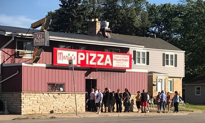 Customers wait in line at Maria's Pizza before it closed in 2022.